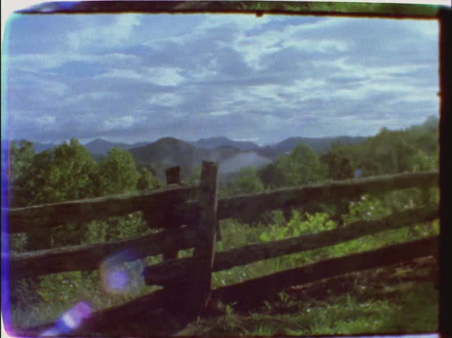 A wooden fence blocks a hillside