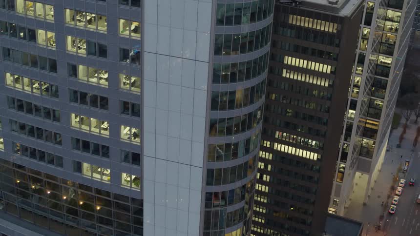 Cars are driving through a downtown city at dusk