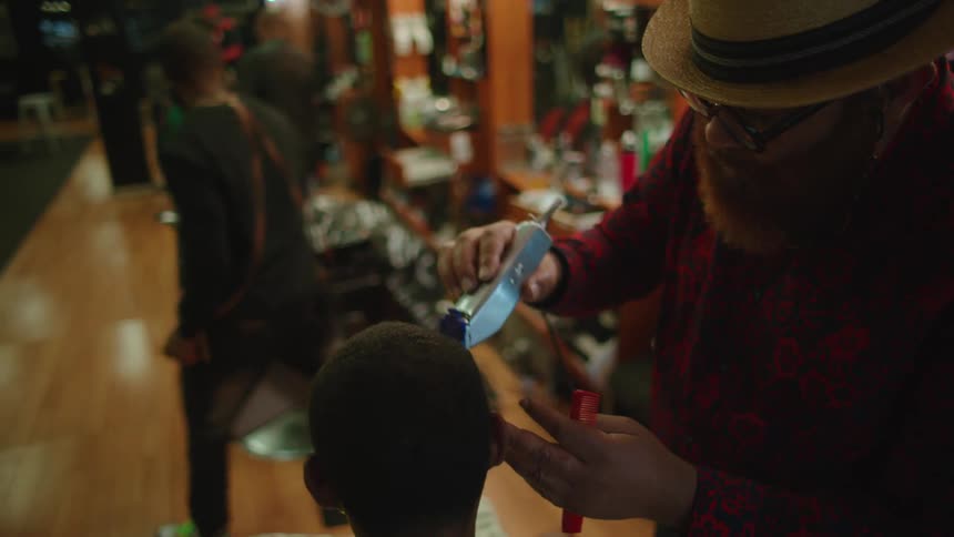 Barbers cut the hair of customers in a barber shop