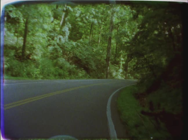 Moving fast down a road surrounded by trees