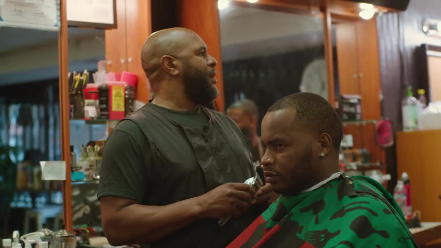 Man changes blade size on an electric shaver before returning to cutting mans hair