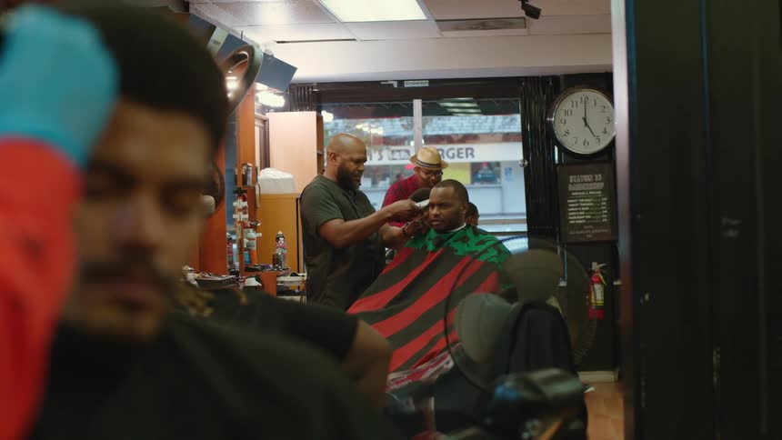 Barbers cut customers hair with hair clippers in barber shop