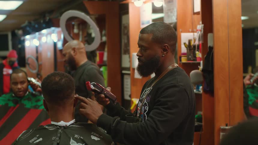 Men get their hair trimmed in a busy barber shop