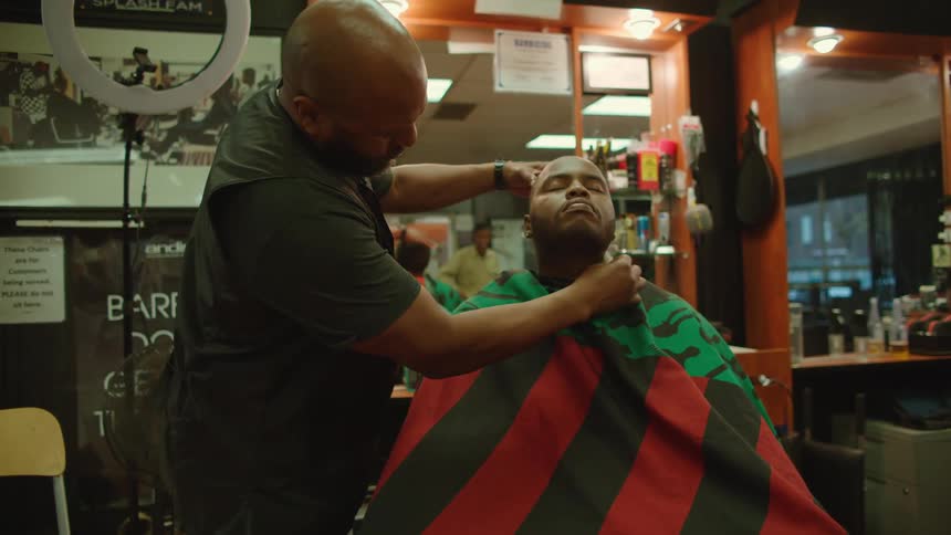 A man is getting a haircut at a barber shop