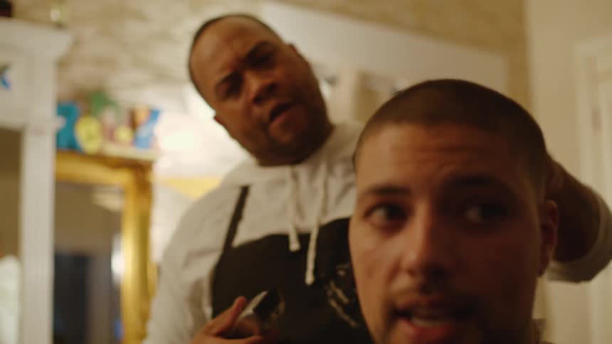 Barber finishing the cut on a clients head with a shaving machine