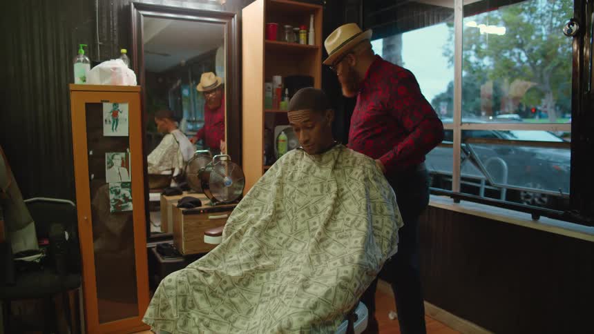 Barber brushes neck of man sitting in barber chair