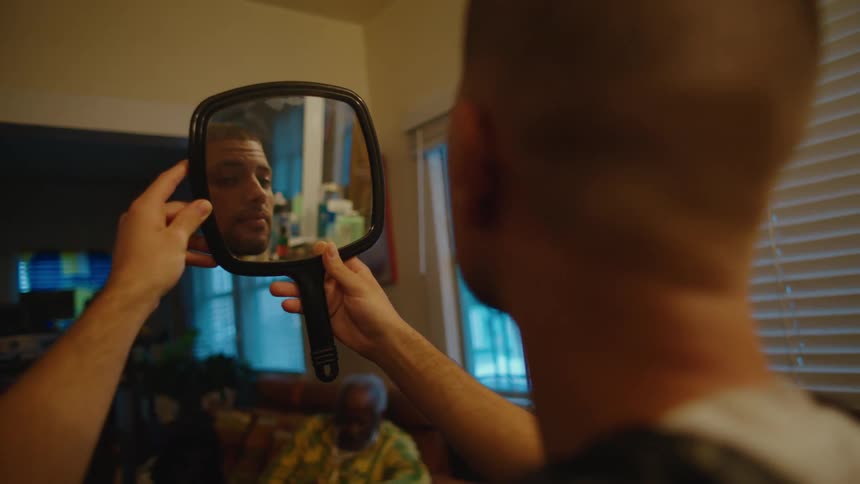 A man is looking at his reflection in a mirror