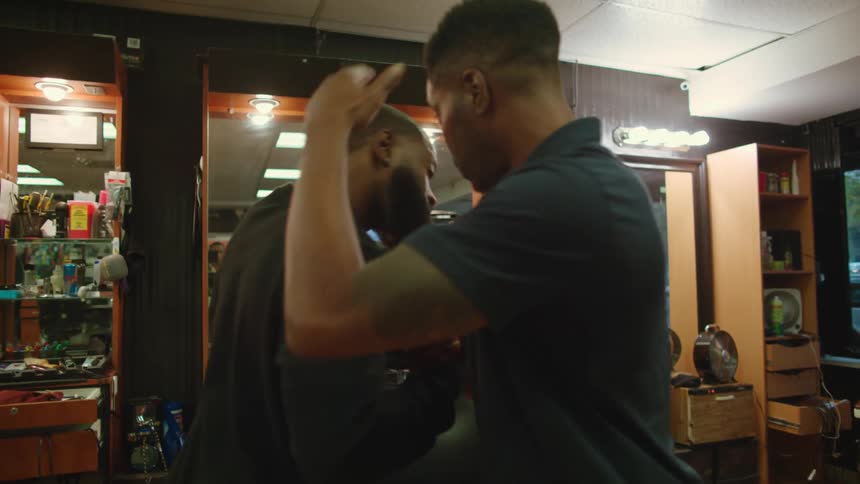 Two men greet each other in the barber shop