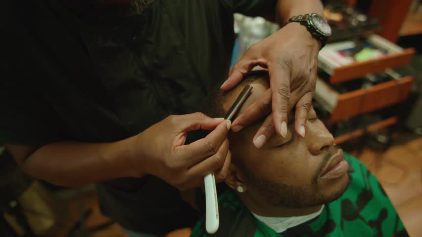 A man is getting his haircut in a barber shop