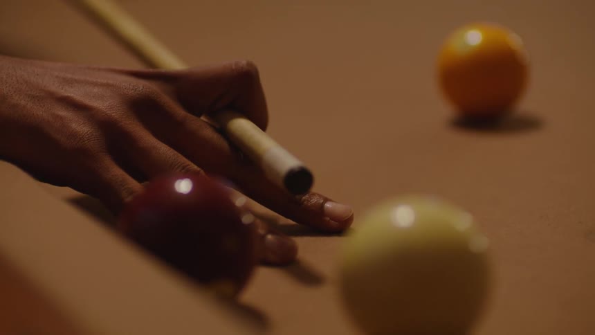 A person playing pool shoots a ball