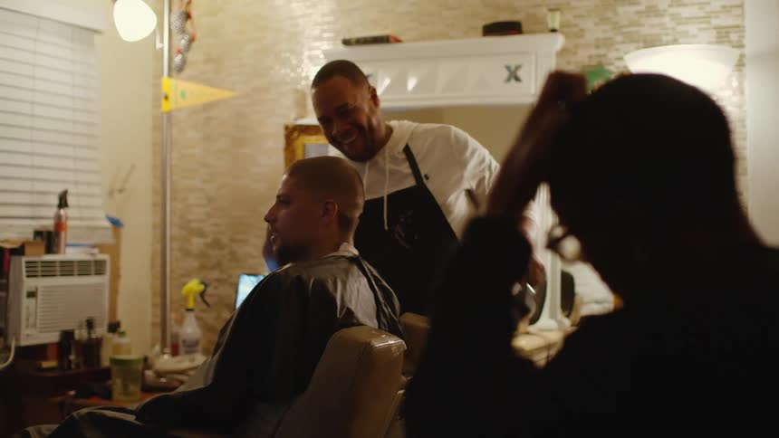 A man is getting his haircut in a barber shop
