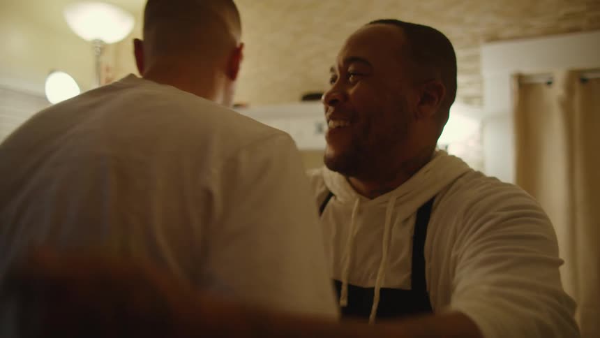 Three men are greeting each other in a room