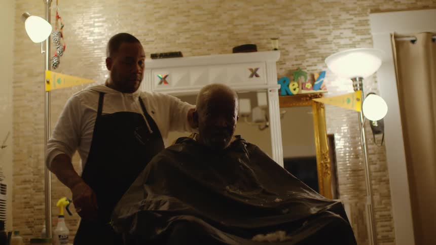 A man is getting a haircut in a barber shop