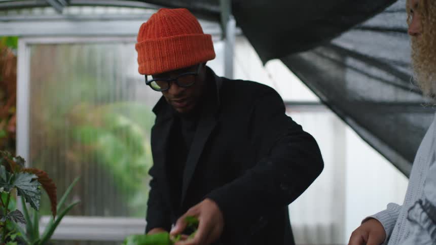 A man and woman washing off peppers outdoors
