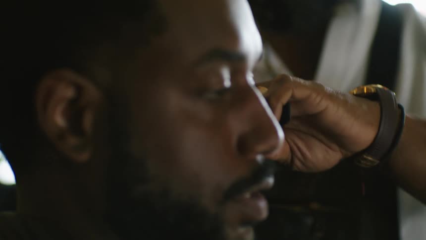 A barber giving a man a haircut in a barbershop
