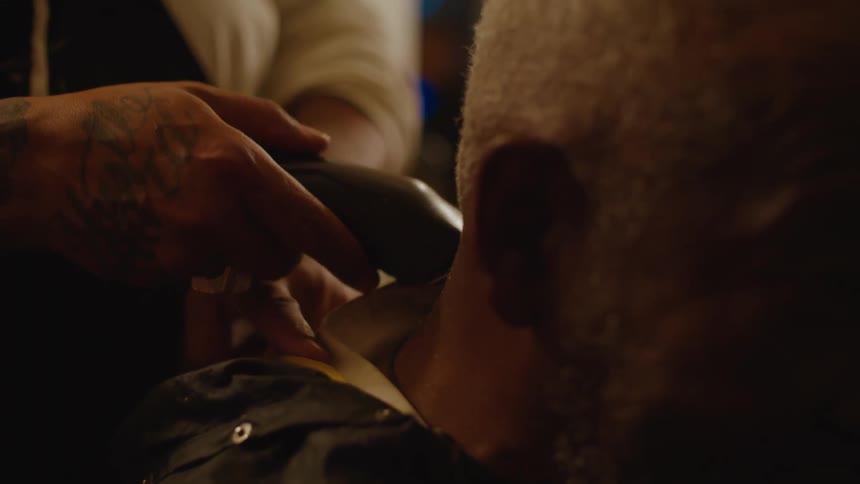 A barber shaves a mans neck