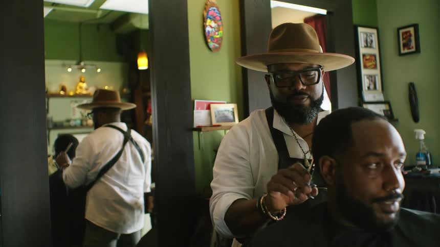 A man is getting his haircut at a barber shop