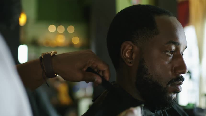 A man is getting a haircut in a barber shop