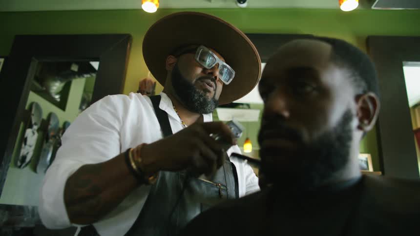 A man is getting his hair cut at a barber shop