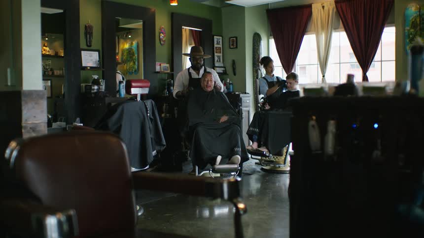 Two men are getting their hair cut in a salon