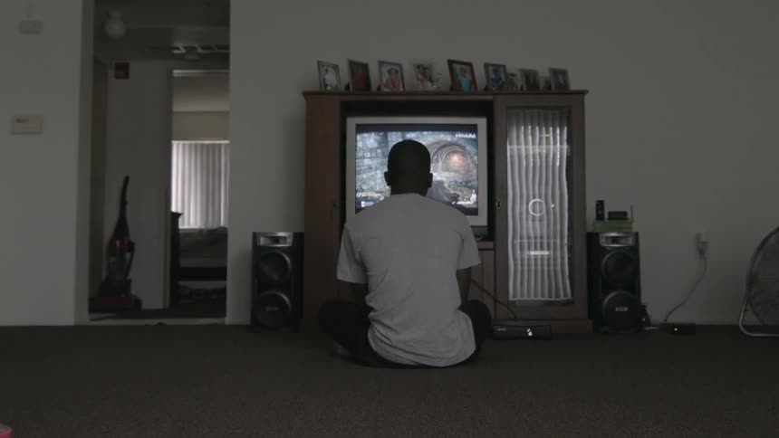 A boy plays a video game on a tv