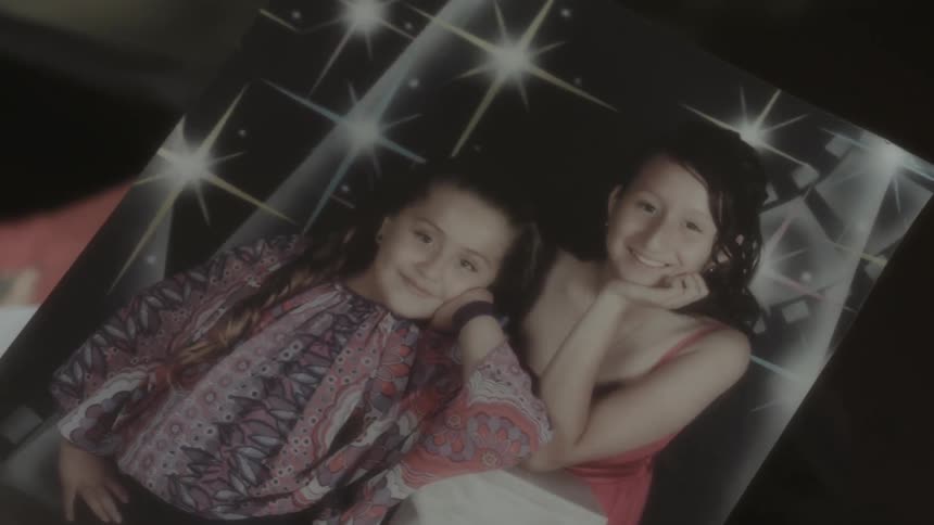 A photograph has two children posing