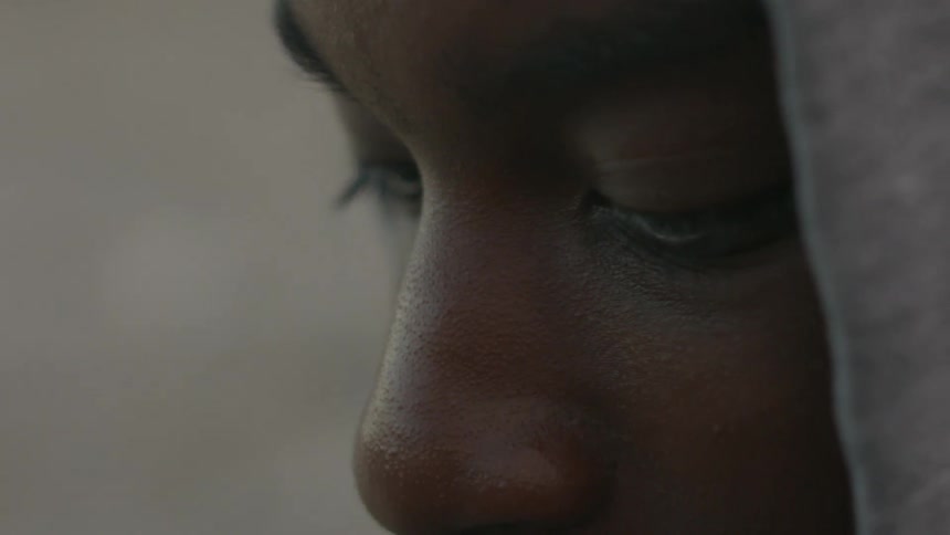A young man in a hood blinks