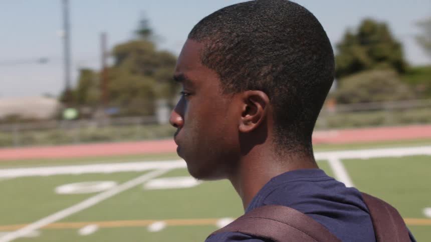 A man looks out across a sports field
