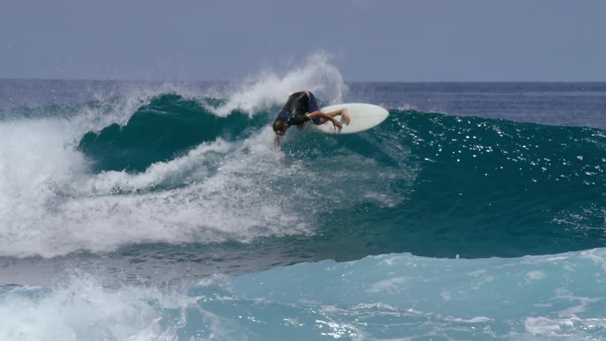 People are surfing on ocean waves at midday