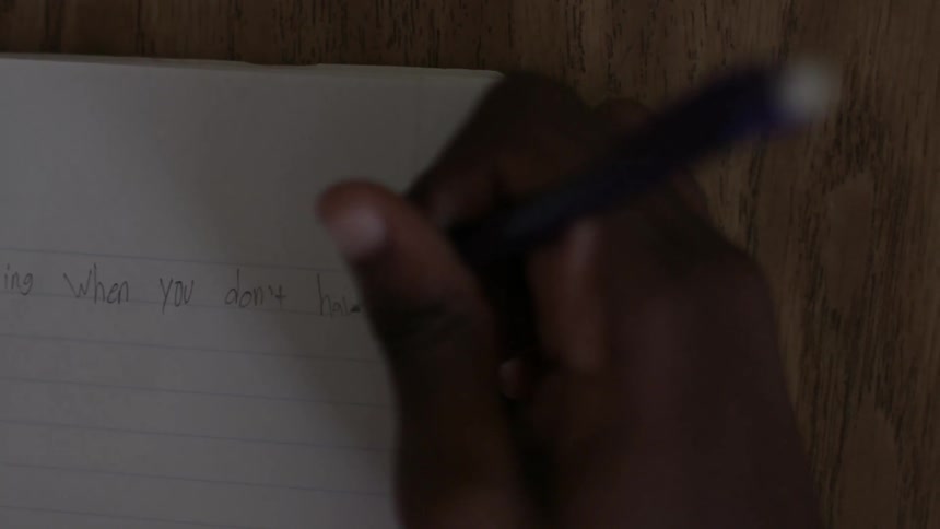 A person is writing in a notebook