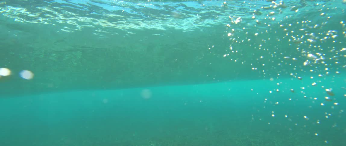 Underwater view of the sun reflecting on the waters surface