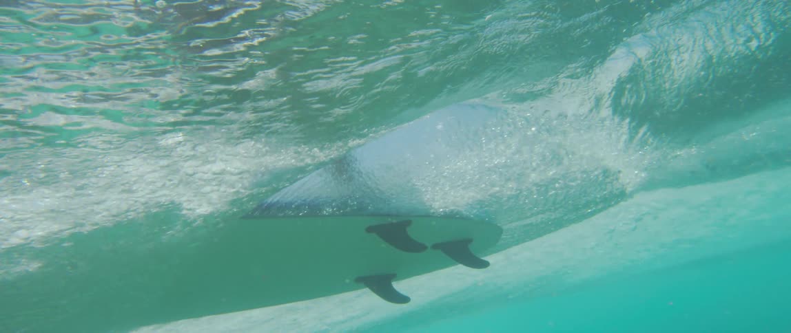 A surfboard floating on top of turquoise ocean water in the daytime