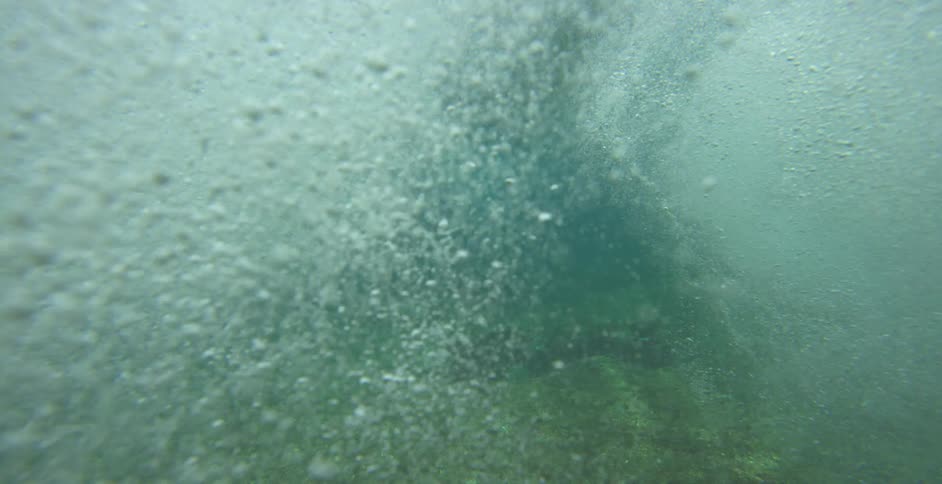An underwater view of ocean waves crashing in the daytime
