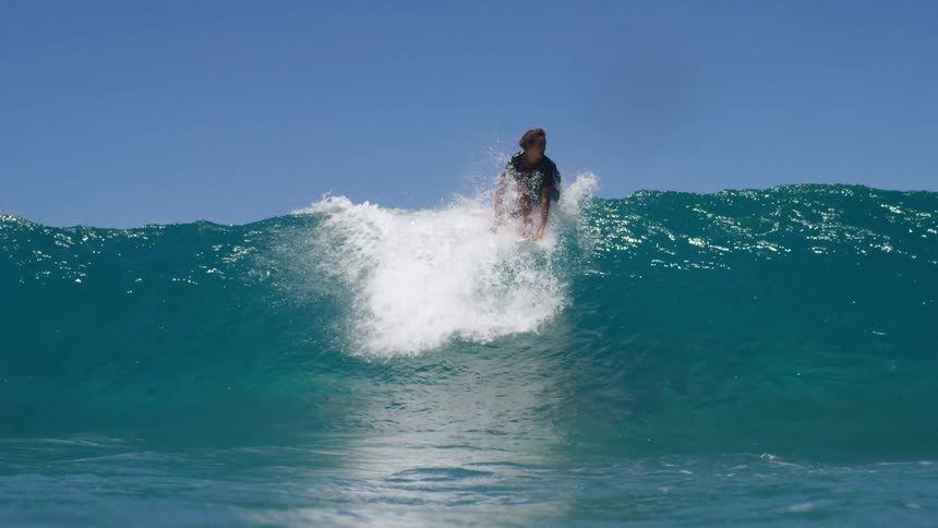 A man is surfing on ocean waves during the daytime