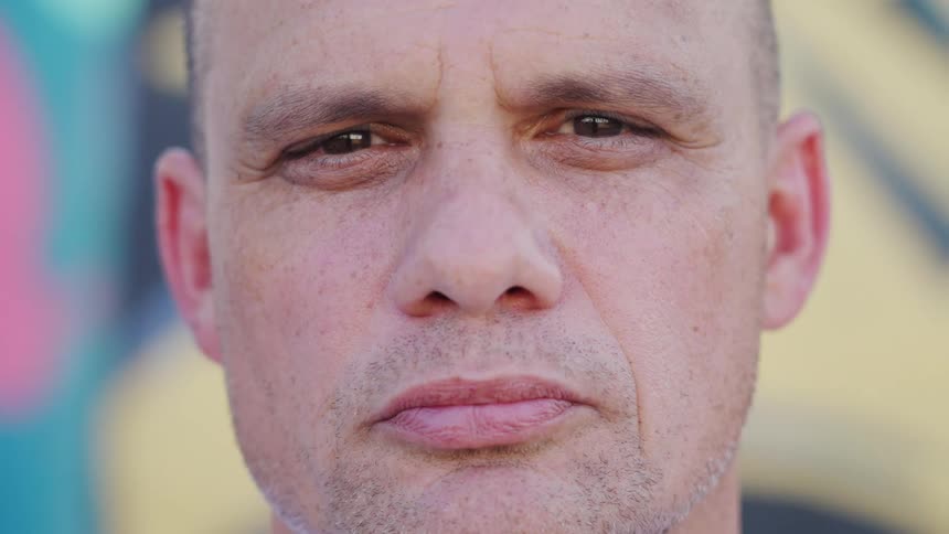 A closeup shot of man looking into the camera with a serious expression