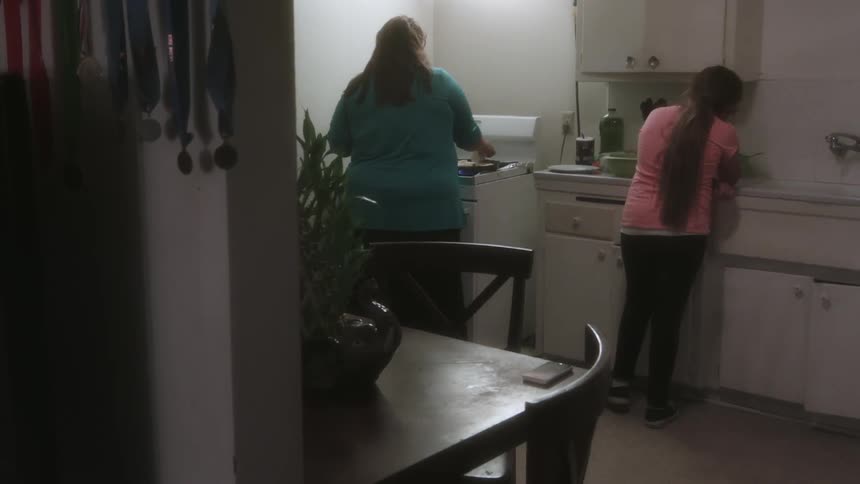 A woman and girl cook in a kitchen