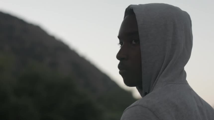 A teenager looks over their shoulder outside