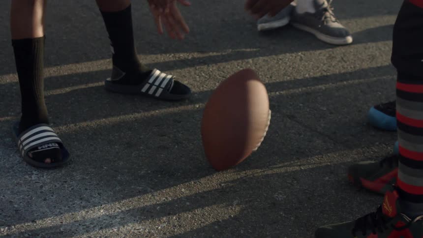A group of people spin a football on the street