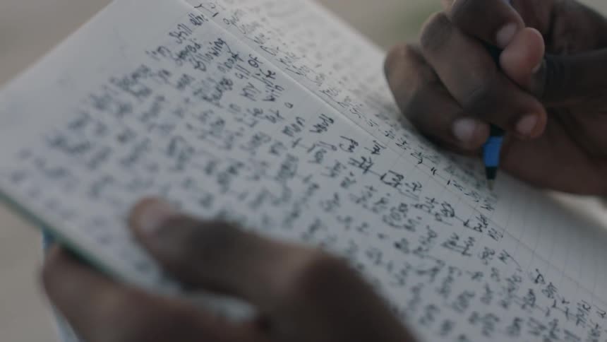 A person is writing in a notebook