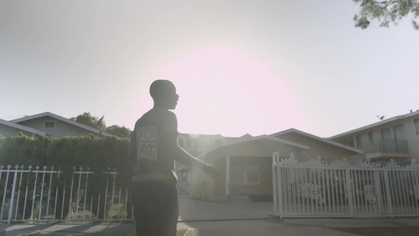 A boy throws a football to others down the street