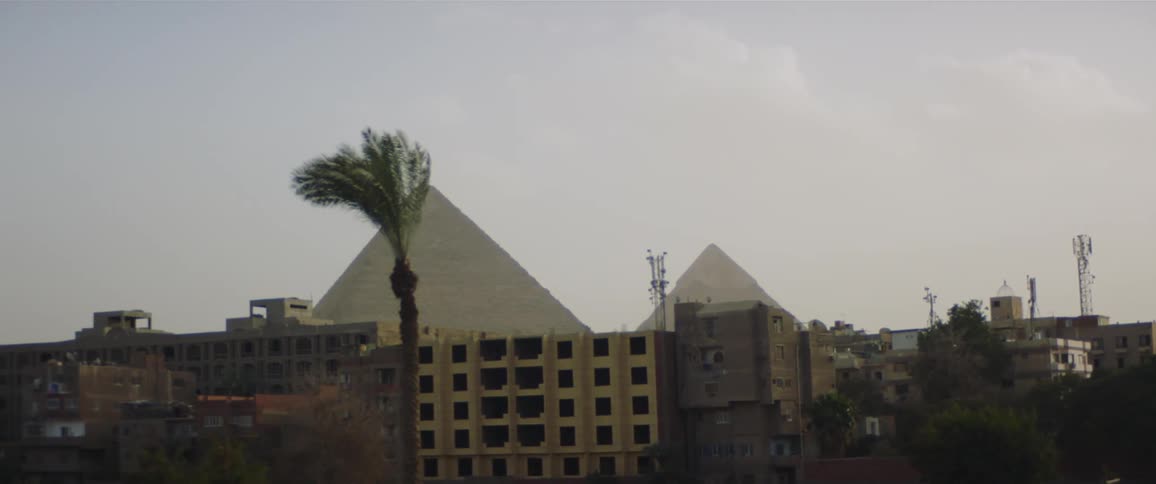 The pyramids of giza at the distance seen from the city at evening