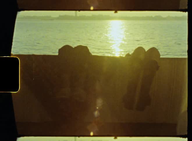 Two people are relaxing on a dock above a river