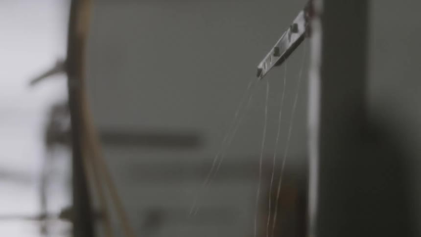 A machine is feeding thread down below