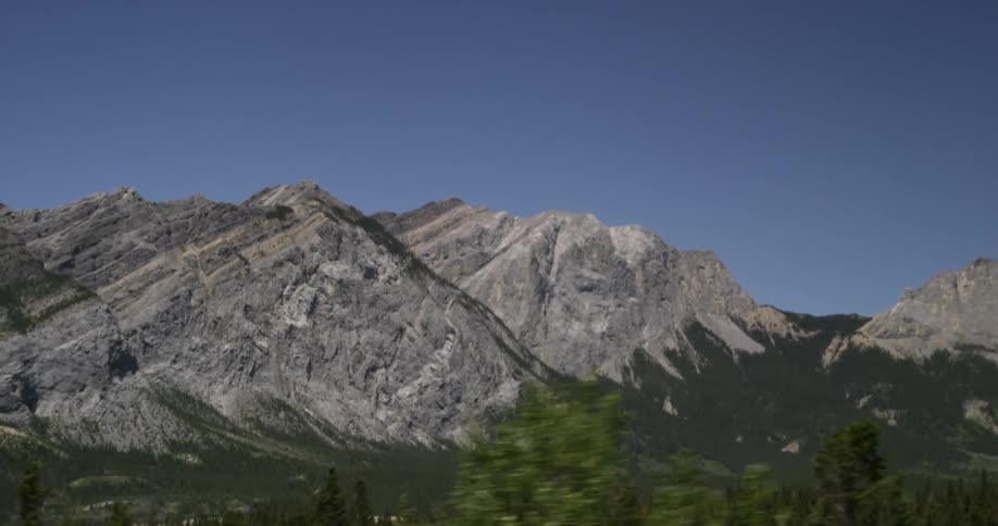 A large mountain range sits on a sunny day