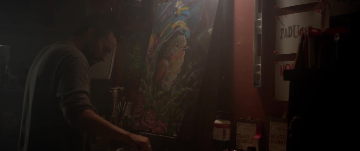 A man begins painting on a canvas