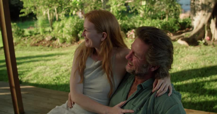 Husband and wife are sitting outdoors and being affectionate