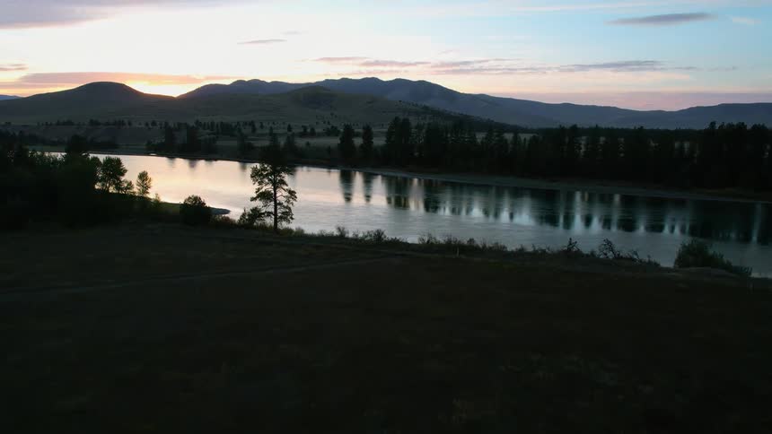 The sun is rising by the river