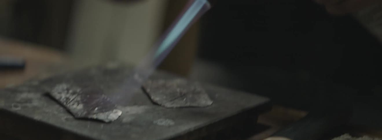 A flame burns a piece of metal
