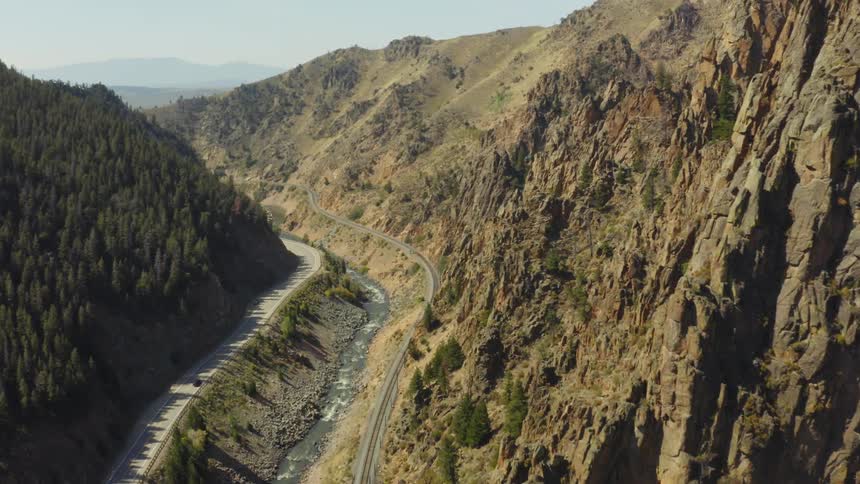 Cars are driving through a mountainous area