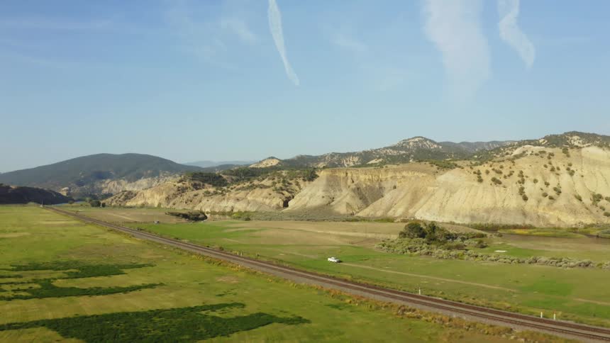Aerial view of railways crossing a grassland plain near the mountains